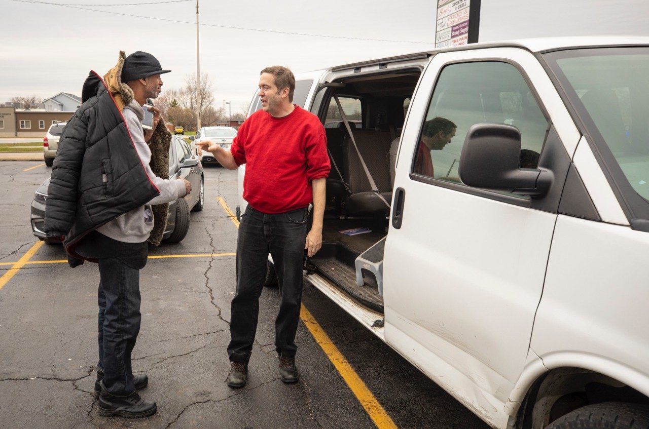 two men standing by a truck talking