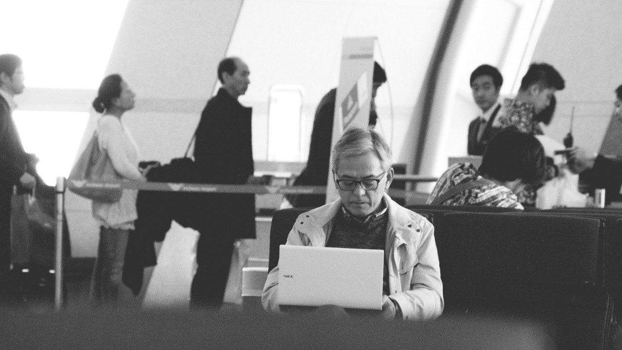 man sitting with his laptop at the airport