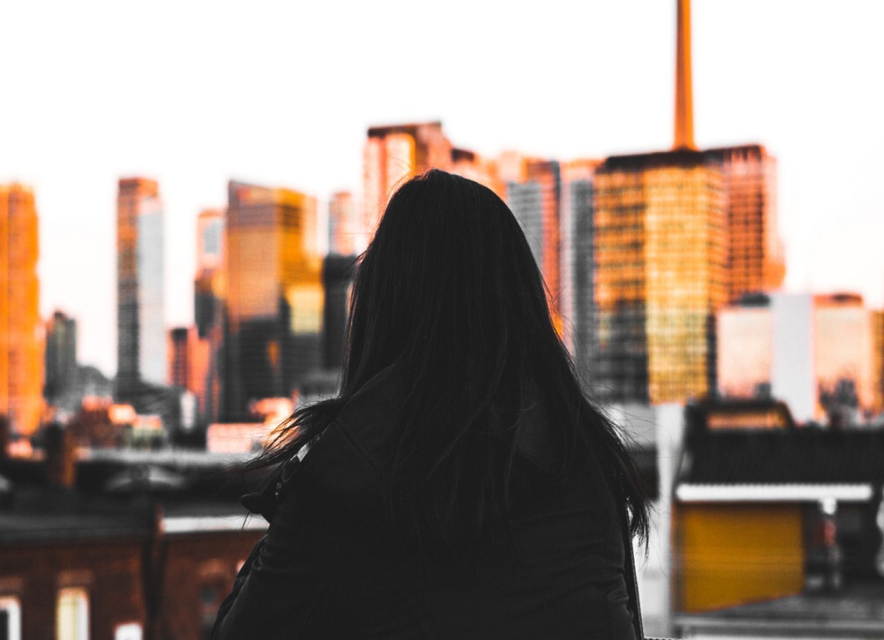 silhouette of girl looking towards city 