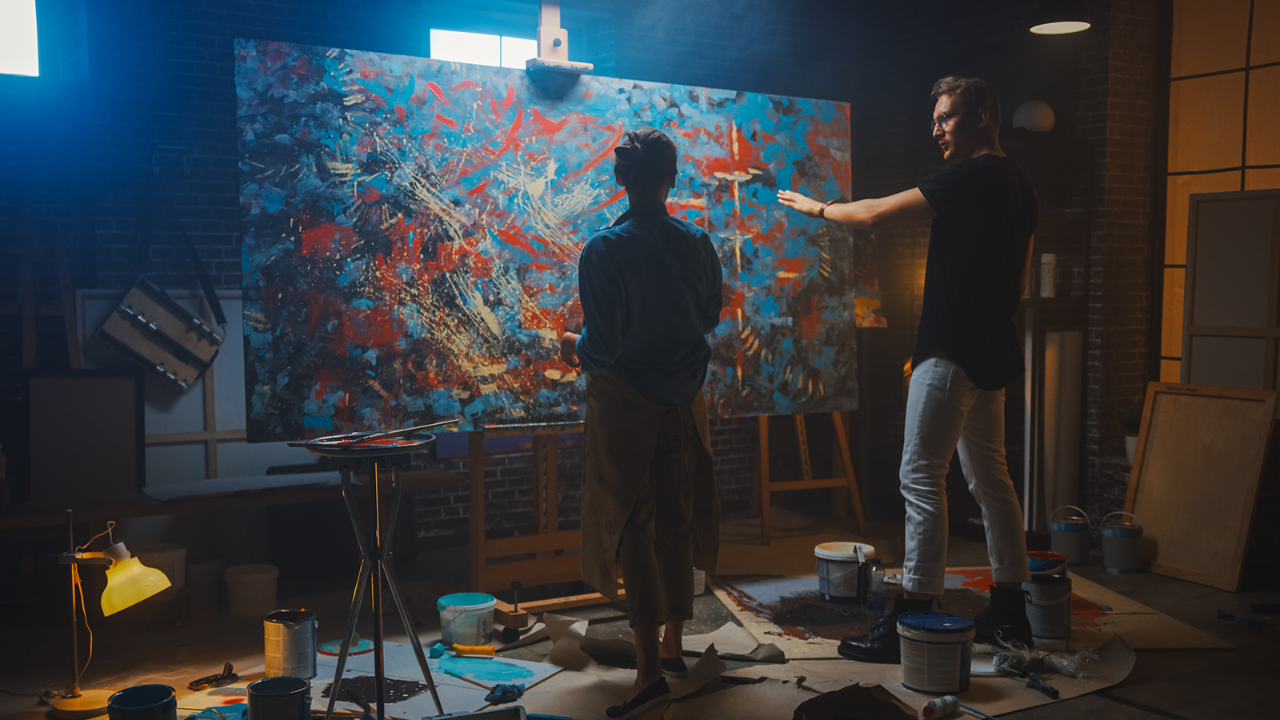 two people talking about a canvas they are painting